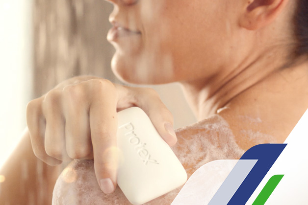 Mujer usando jabón protex