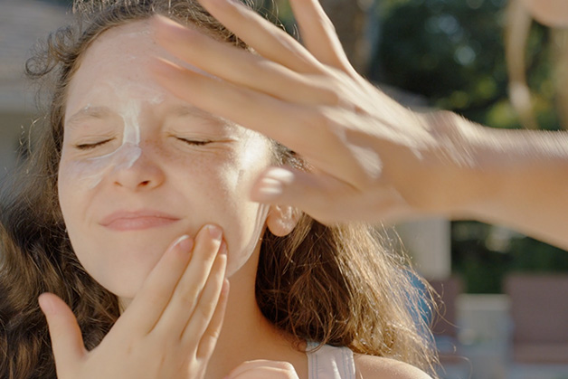Girl with a tower in front of a mirror on a bathroom